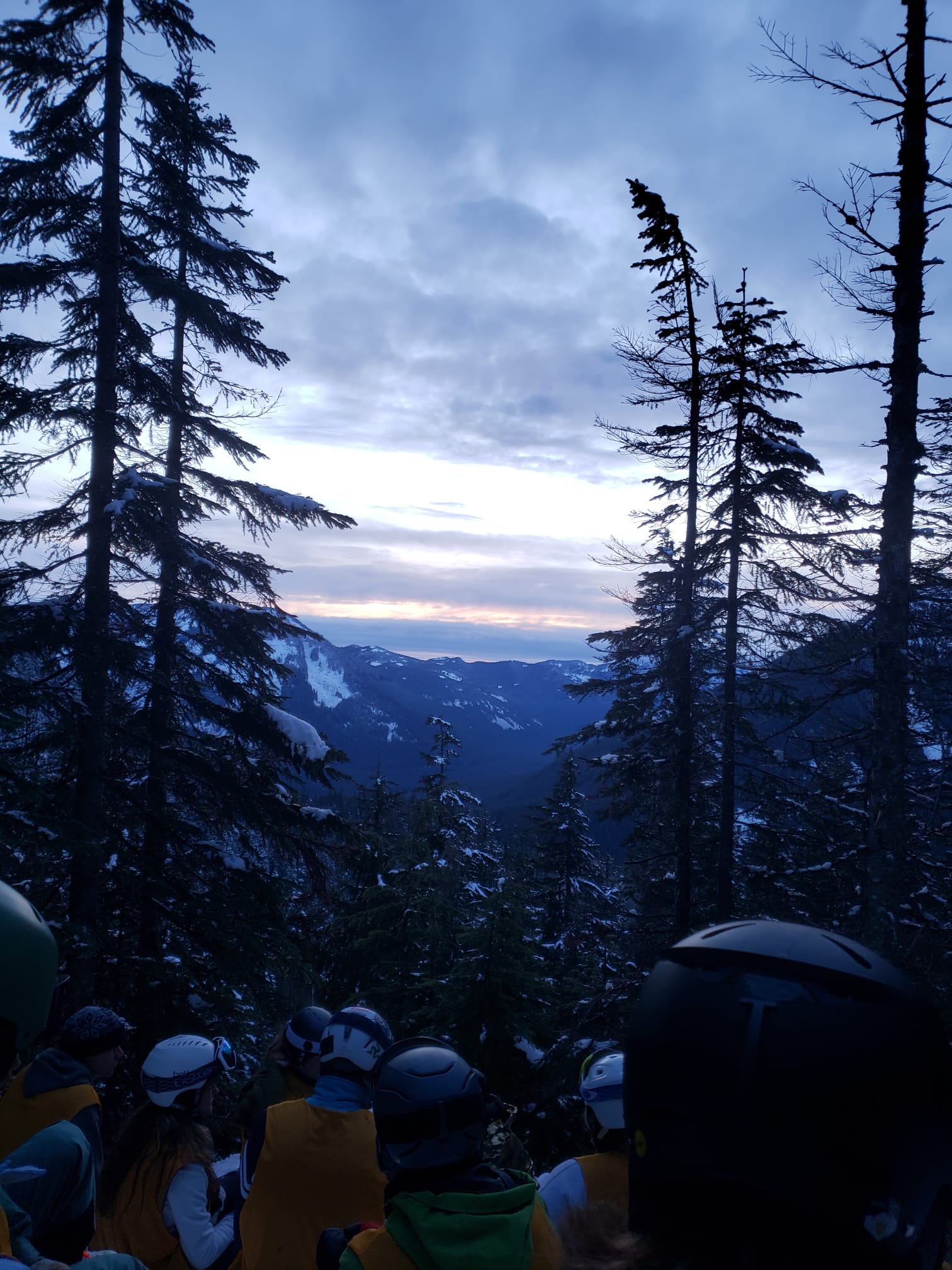 Husky Winter Sports members watching the sunset on a mountain